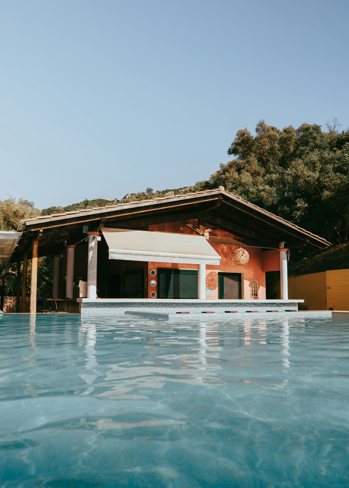 Discover a serene villa retreat in Corfu with a refreshing swimming pool and lush surroundings. Perfect for a summer getaway.
